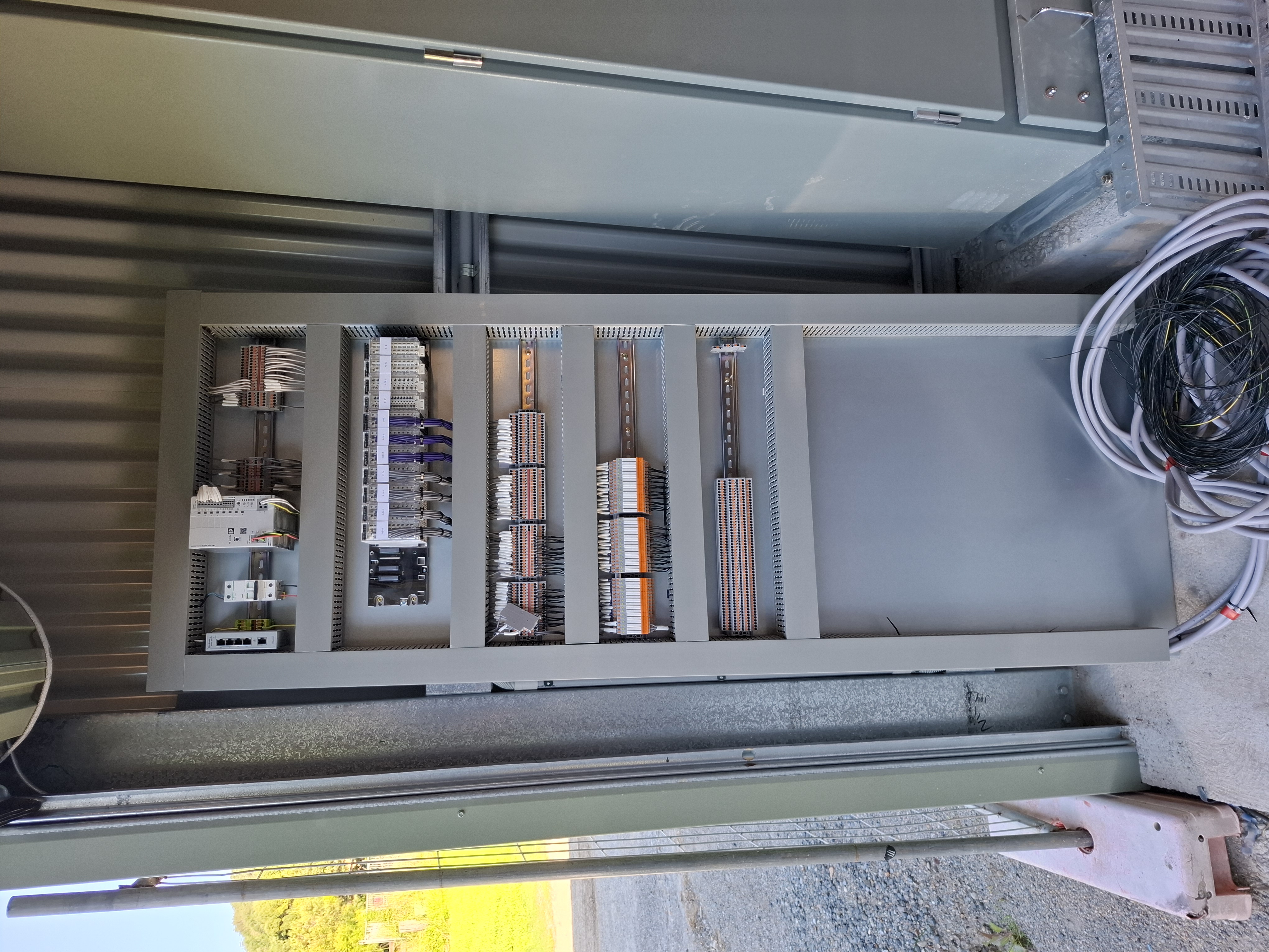 Control panel internal — Modicon PLC, network switch, 24V supply and orderly terminal layout